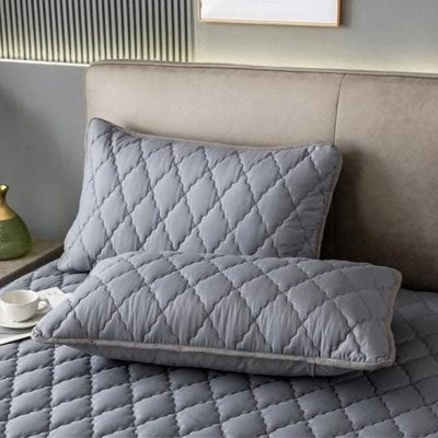 Taie d'oreiller premium coton doux gris sur lit gris accompagné d'une tasse de café