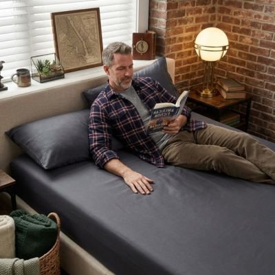 Drap housse gris anthracite homme lit son livre paisiblement