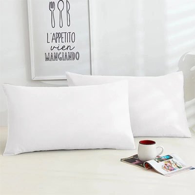 Taie d'oreiller douceur réparatrice blanc sur lit blanc avec revue et café bien disposés