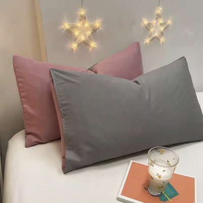 Taie d'oreiller respirante premium rose gris lit bien fait avec oreillers colorés accompagné d'un livre et un verre de lait